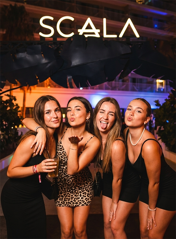 Amigas disfrutando de la noche y posando en la entrada del club Scala